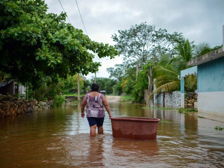 A woman from the Mayan community of Tecoh wades through the water in a flood caused by Tropical Storm Cristobal in the town of Tecoh, near Merida in Yucatan State, Mexico, in June 2020. (Luis Perez/AFP via Getty Images)