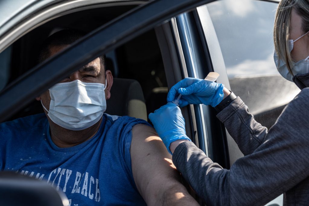 Vaccine Clinic At University Of Louisville Stadium To Vaccinate 4000 People A Day A medical professional from UofL Health administers a vaccine to a patient in their vehicle