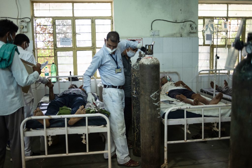 Medical attendant Gurmesh Kumawat prepares to administer supplemental oxygen to a coronavirus patient in the emergency ward at the BDM Government Hospital last week in Kotputli, Jaipur District, Rajasthan, India. (Rebecca Conway/Getty Images)