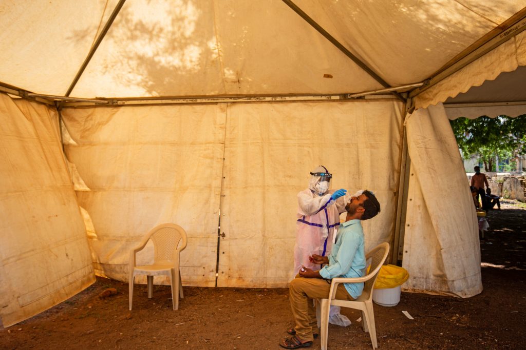 A medic performs an oral swab test for the coronavirus this week in Mysore, Karnataka, India. India's prolonged and debilitating wave of infections has reached deep into rural India, where the true extent of devastation may never be known because of a lack of widespread testing or reliable data. (Abhishek Chinnappa/Getty Images)