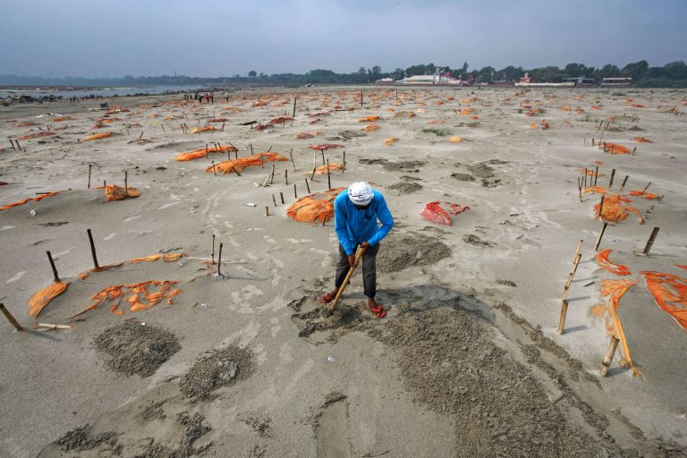 Rains have washed away the top layer of sand of shallow graves at a cremation ground on the banks of the Ganges River in Shringverpur, northwest of Allahabad, Uttar Pradesh, India. Coronavirus testing is limited in parts of rural India, but some of the people buried there are believed to have died of COVID-19. (Ritesh Shukla/Getty Images)