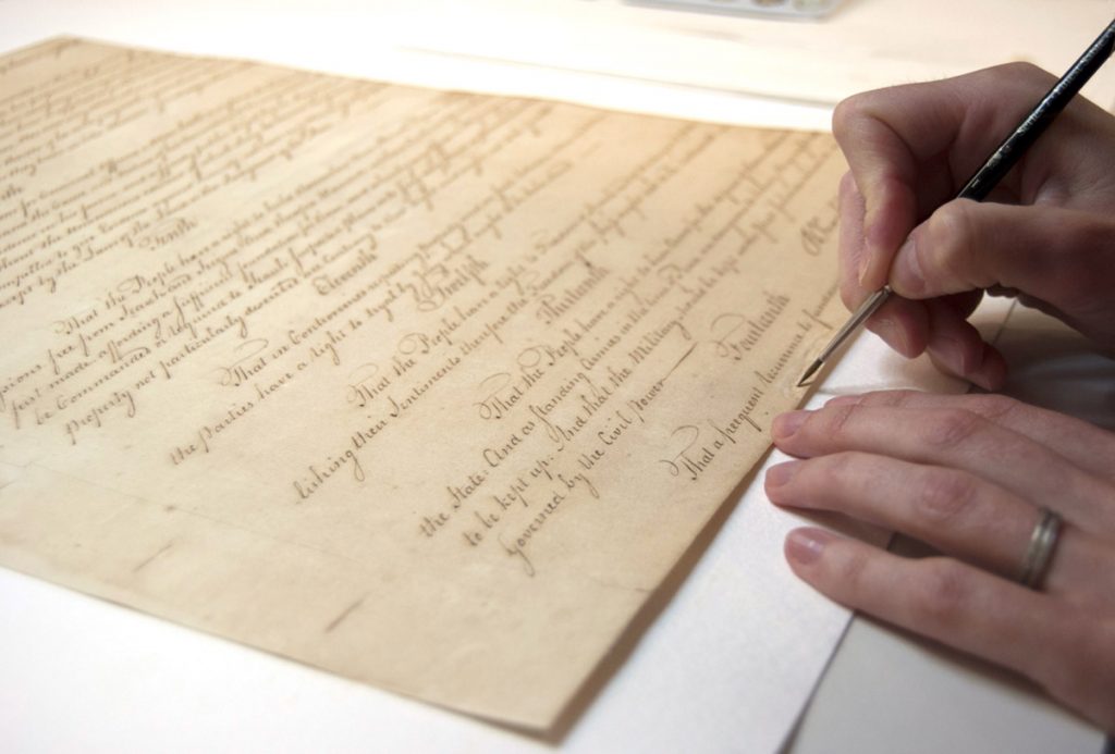 pennsylvaniaconstitution-conservators A person's hand holds a pen to the Pa. Constitution