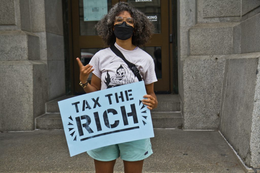 2021 06 08 k paynter after protest outside kenney officer Sam Rise holds a sign that says,