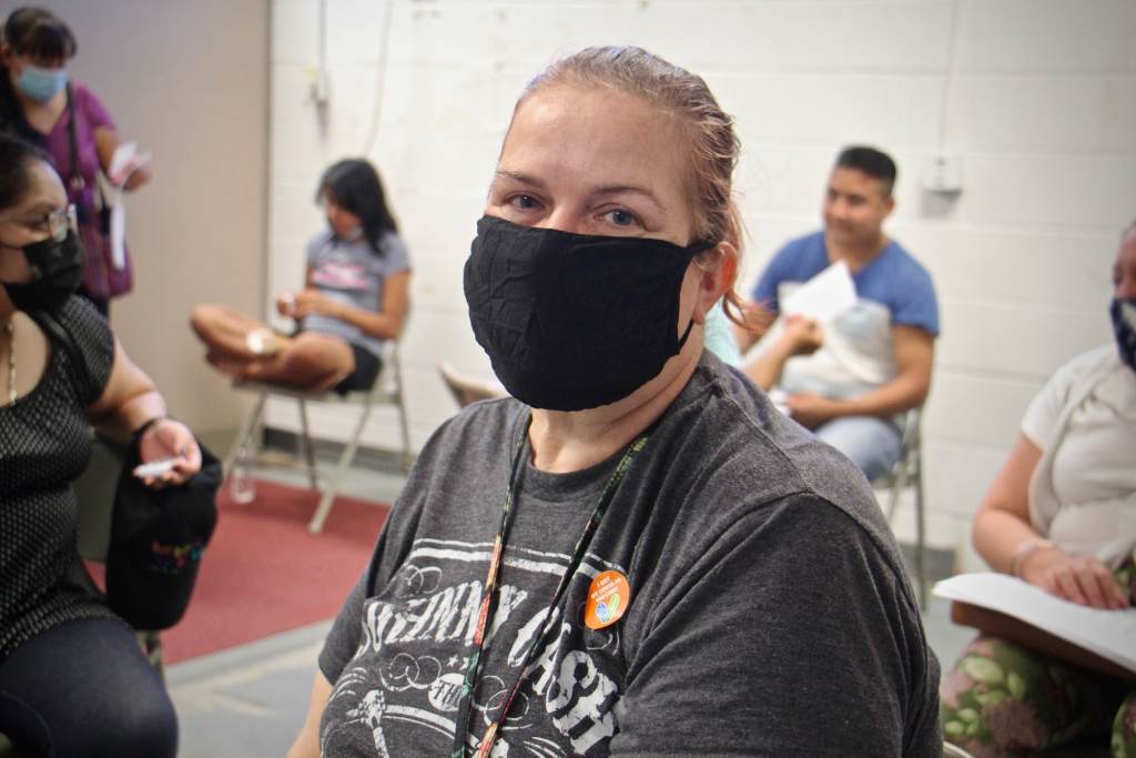 Samantha Madden sits while wearing a black face mask