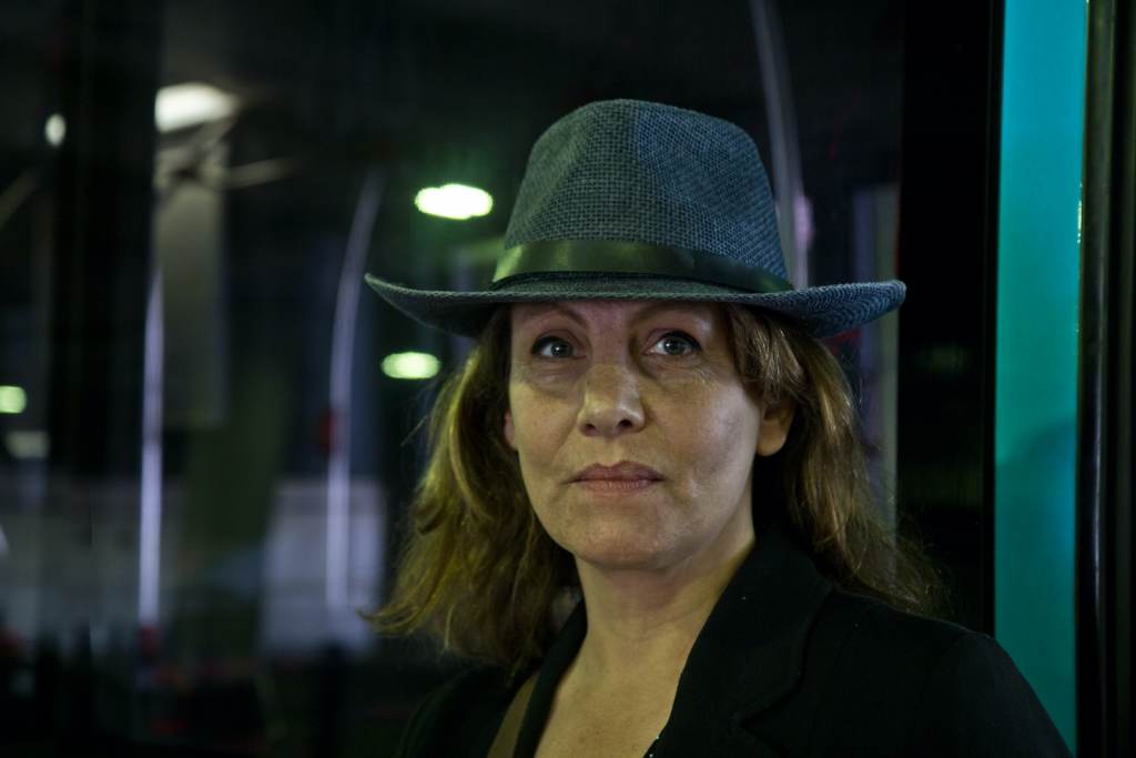 Isabelle Rigollaud wears a hat inside a transportation center