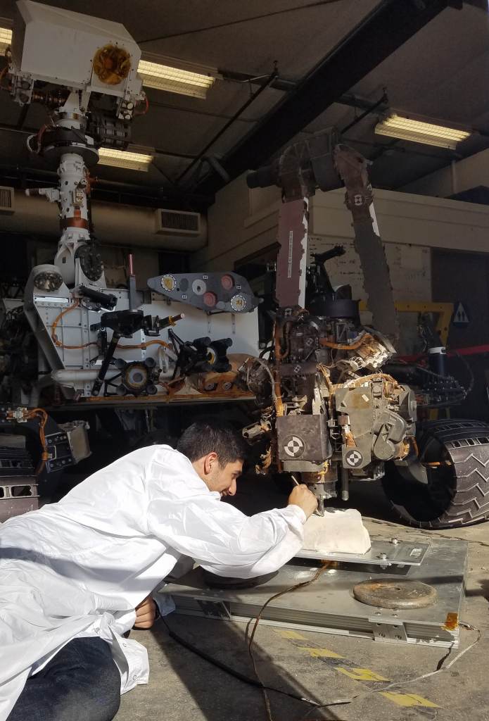NASA robotics engineer Vladimir Arutyunov tests a new way for the Mars rover Curiosity to drill, using a clone of the rover on Earth. Photo courtesy of NASA/JPL-Caltech.