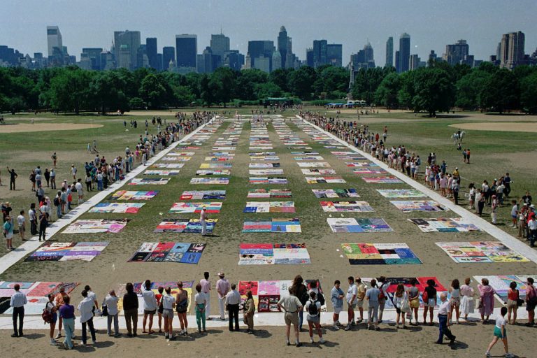 Onlookers watch as almost 1,500 quilt panels bearing the names of New York area residents who have died of AIDS are unfolded on the Great Lawn