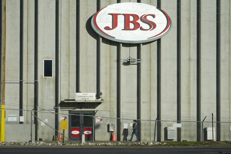 A worker walks into a JBS meat packing plant