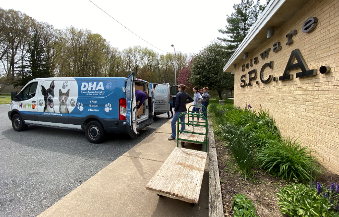 People stand outside a DHA van ready to help