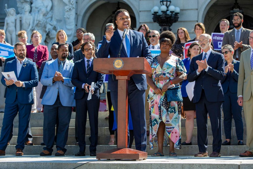 PA_lawmakers_LGBTQ_protections_SPA_061621 Rep. Malcolm Kenyatta speaks at a podium, with a group of lawmakers behind him