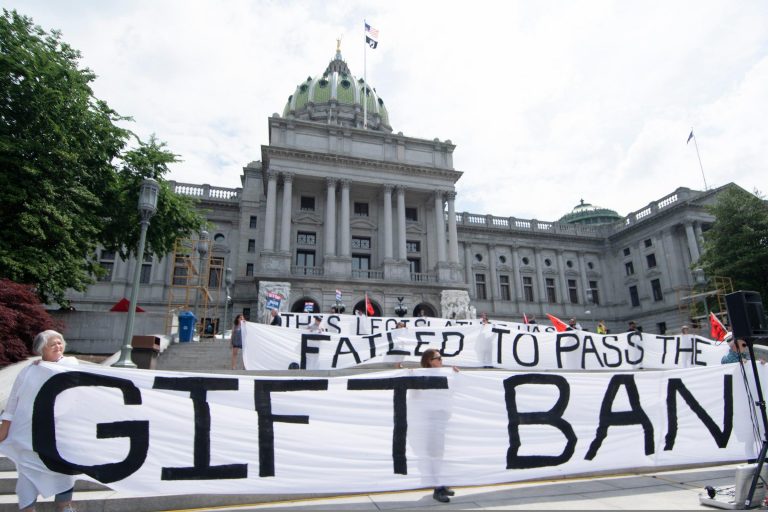 Activists hold up a sign that says, 