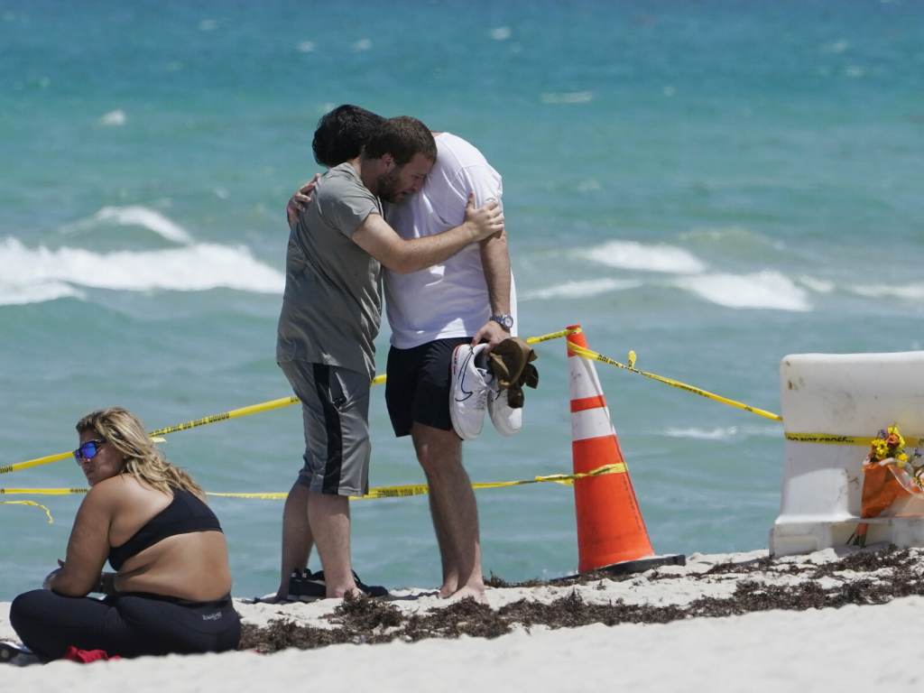 Building Collapse Miami Two men console each other on the beach