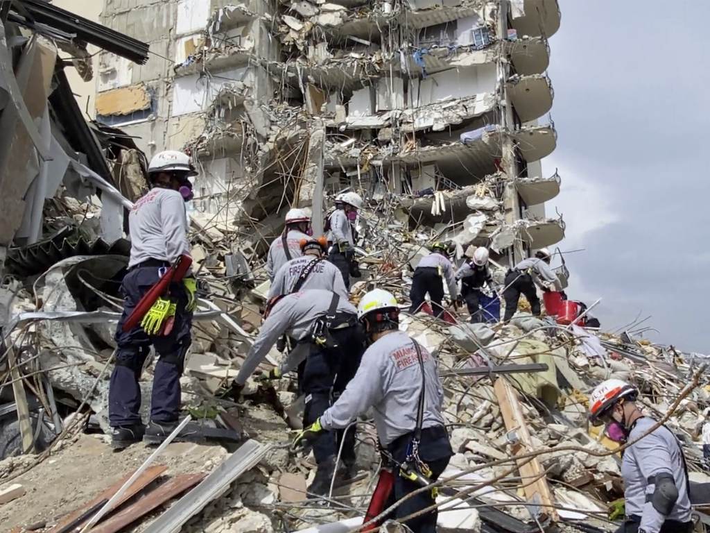 In this photo provided by Miami-Dade Fire Rescue, search-and-rescue personnel search for survivors through the rubble at the Champlain Towers South Condo in Surfside, Fla., on Friday. Search and rescue personnel search for survivors through the rubble at the Champlain Towers South Condo