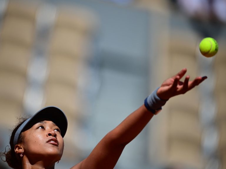 Japan's Naomi Osaka eyes the ball as she serves to Romania's Patricia Maria Tig