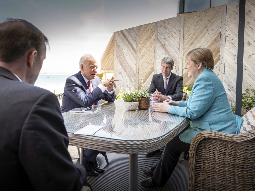 President Biden meets with German Chancellor Angela Merkel on the sidelines of the G-7 summit. A White House official said Biden did a lot of “diplomatic speed-dating” with world leaders. Chancellor Angela Merkel and US President Joe Biden speak while sitting at a table