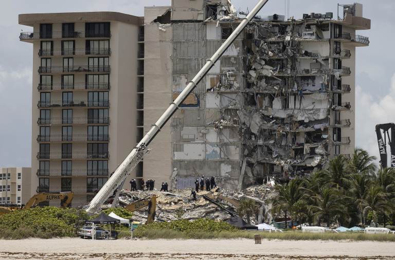 Members of the South Florida Urban Search and Rescue team look for possible survivors in the partially collapsed 12-story Champlain Towers South condo building