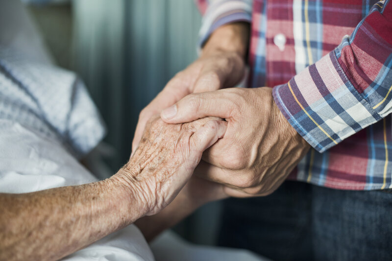 Close up of son holding his mothers hands Close up of son holding his mothers hands in hospital