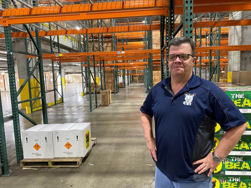 Mike Collar stands inside a warehouse