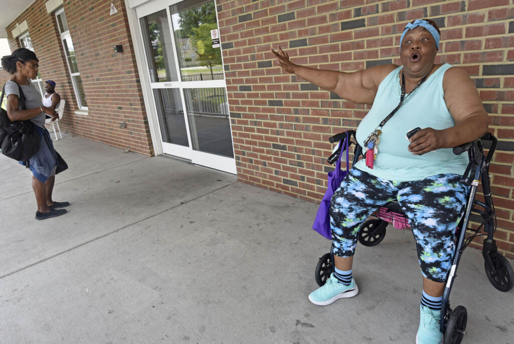 01-9 On July 9, Ferry Station tenant Sarah Rogers, right, tries to prevent a non-resident from entering her senior apartment complex, where trespassers have been sleeping in community areas and hallways, frightening residents and sometimes leaving human excrement behind. (April Saul for WHYY)