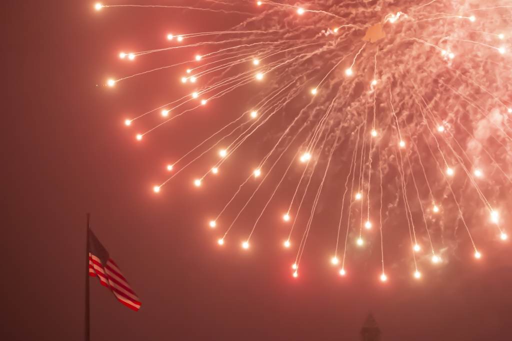 JULY 4TH FIREWORKS AT PHILADELPHIA MUSEUM OF ART An American flag flutters as fireworks rain down during the July Fourth fireworks display at the Philadelphia Museum of Art. (Jonathan Wilson for WHYY)