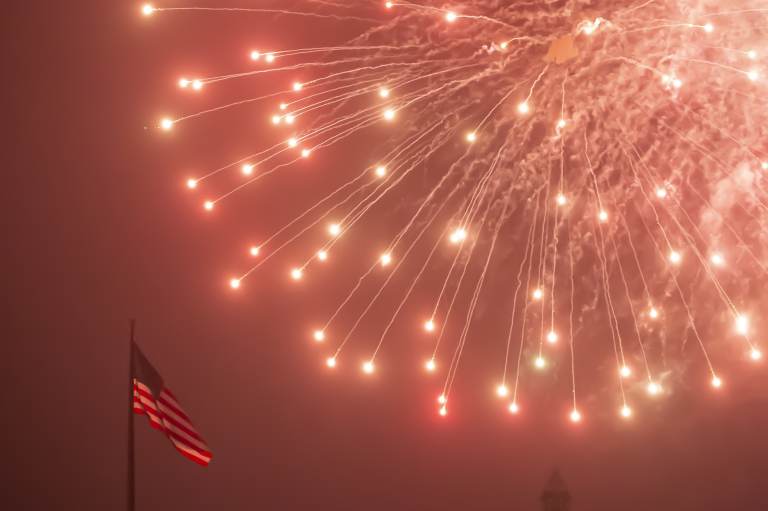 An American flag flutters as fireworks rain down during the July Fourth fireworks display at the Philadelphia Museum of Art. (Jonathan Wilson for WHYY)
