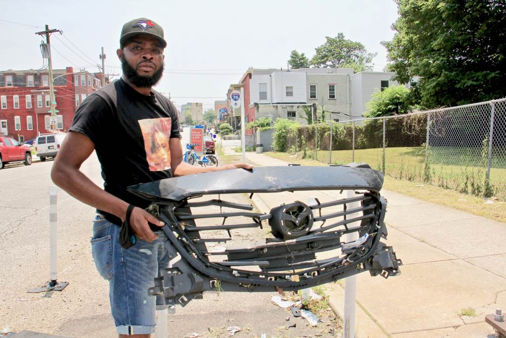 2021 07 06-e lee-dewayne drummond-philadelphia mantua-traffic safety grill De'Wayne Drummond picks up a grill left behind after a crash at 34th Street and Mantua Avenue