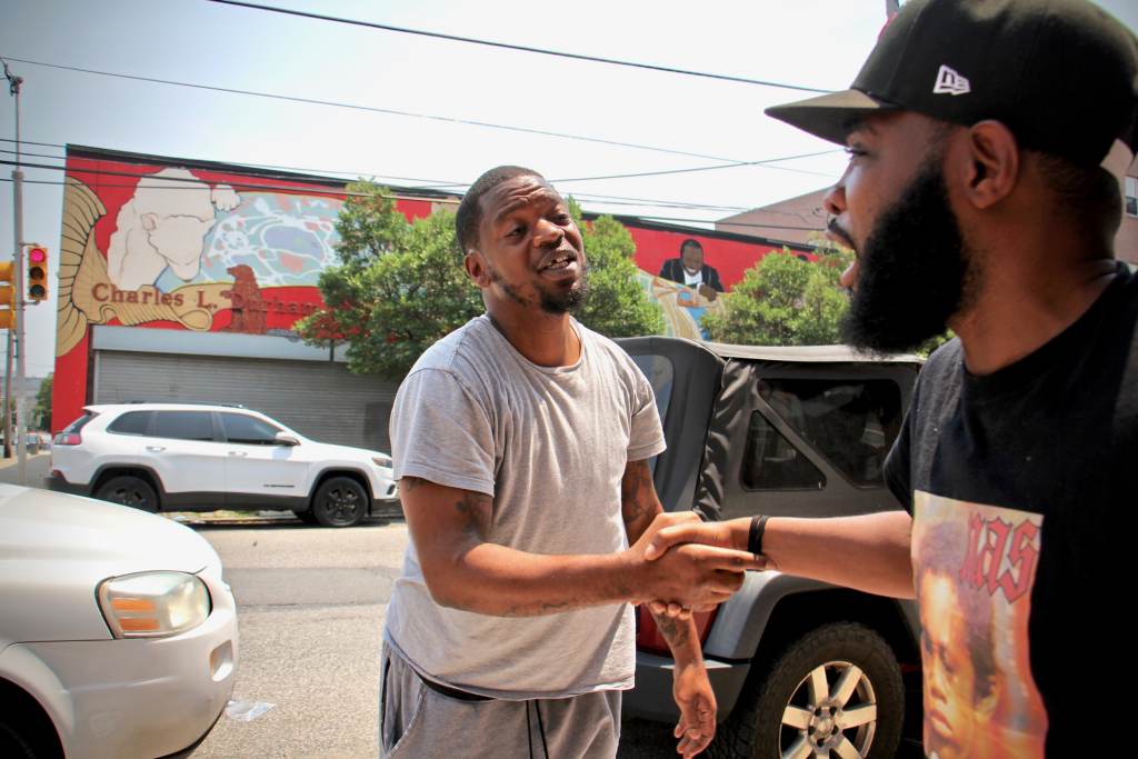 Forrest Carroll (left) and De'Wayne Drummon shake hands outside