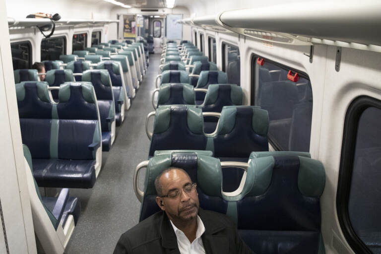 FILE - In this March 17, 2020 file photo, a commuter sits in an otherwise empty car as he waits for the 7:58 p.m. train to Hudson to leave Grand Central Terminal, in New York.  The eruption of COVID-19  across the United States last year caused the proportion of people working from home to nearly double, with the shift most pronounced among college graduates and workers in such fields as finance and professional services. The share of employed people working from home rose shot up from just 22% in 2019 to 42% in 2020.  (AP Photo/Mary Altaffer)
