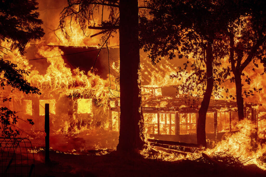 Flames from the Dixie Fire consume a home in the Indian Falls community