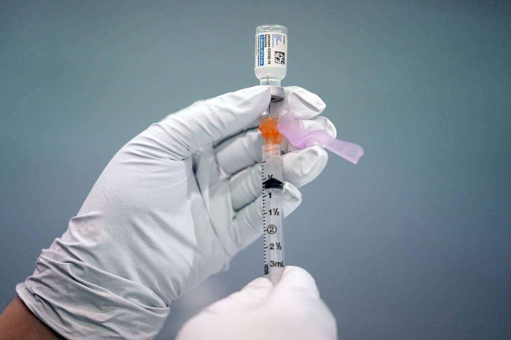 Virus Outbreak J&J Vaccine A gloved hand holds up a syringe of the COVID-19 vaccine
