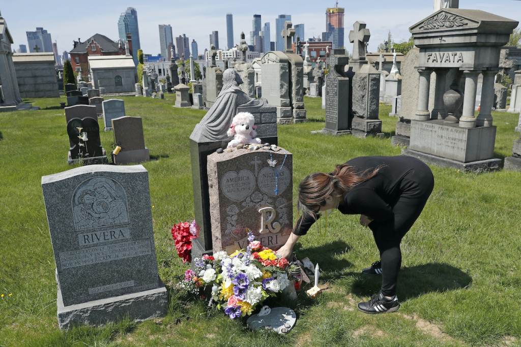 Overdose Deaths Record Sharon Rivera adjusts flowers and other items left at the grave of her daughter, Victoria