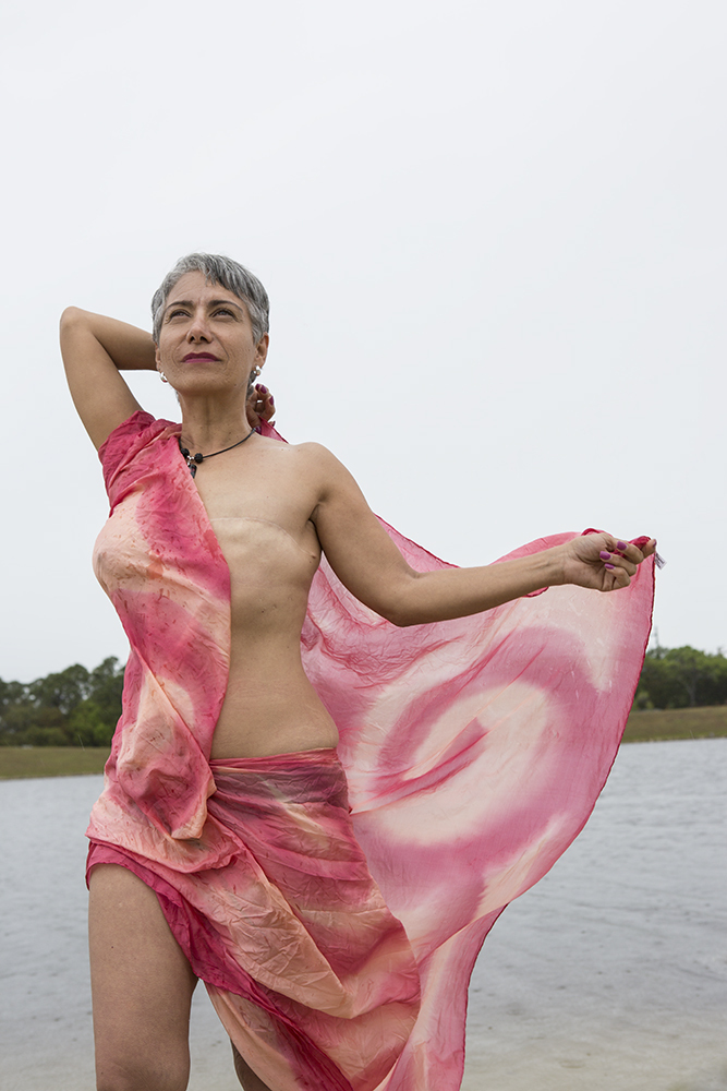 A breast cancer patient is pictured wearing a wrap, evoking a goddess