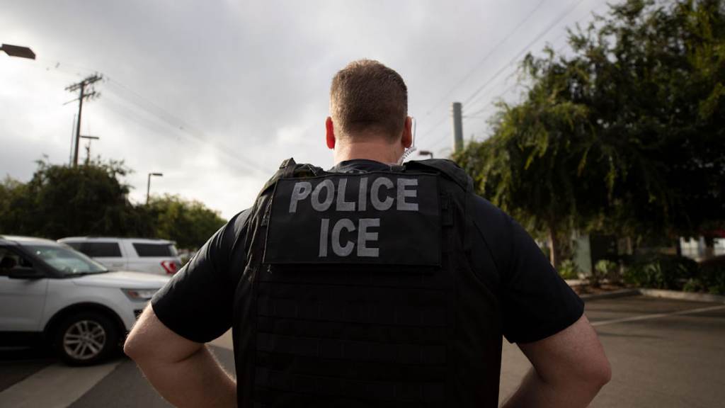 Immigration An Immigration and Customs Enforcement officer is seen from behind.