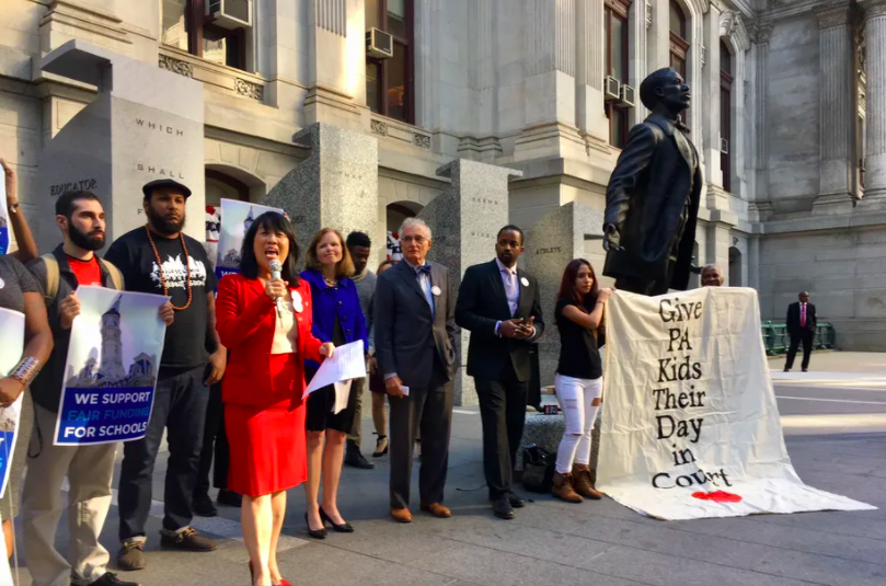 Before Philadelphia’s City Hall, plaintiffs and their attorneys celebrate an earlier court ruling allowing their fair funding case to proceed. (Darryl Murphy / The Notebook)