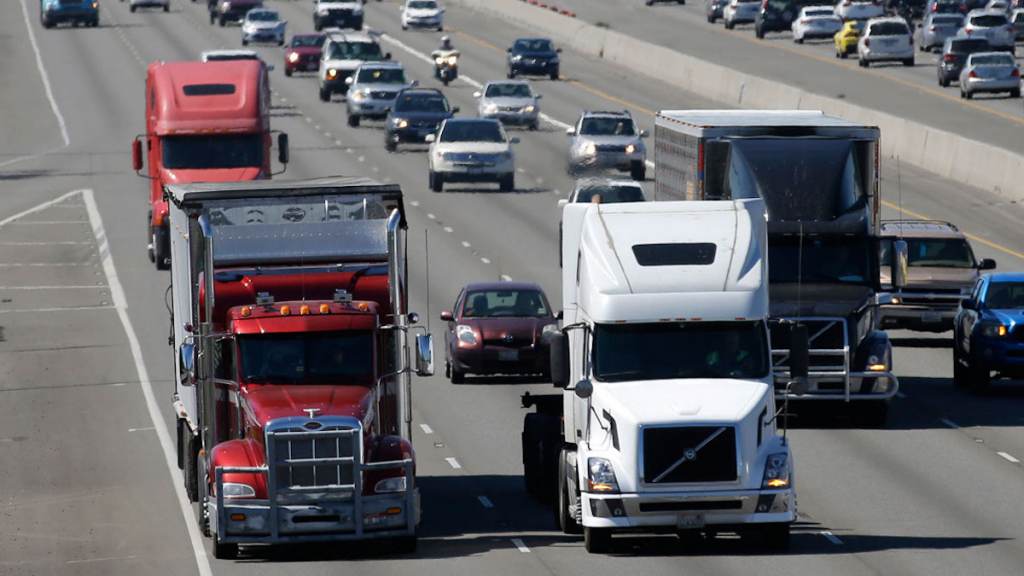 Self Driving Trucks Trucks and cars travel down the highway.