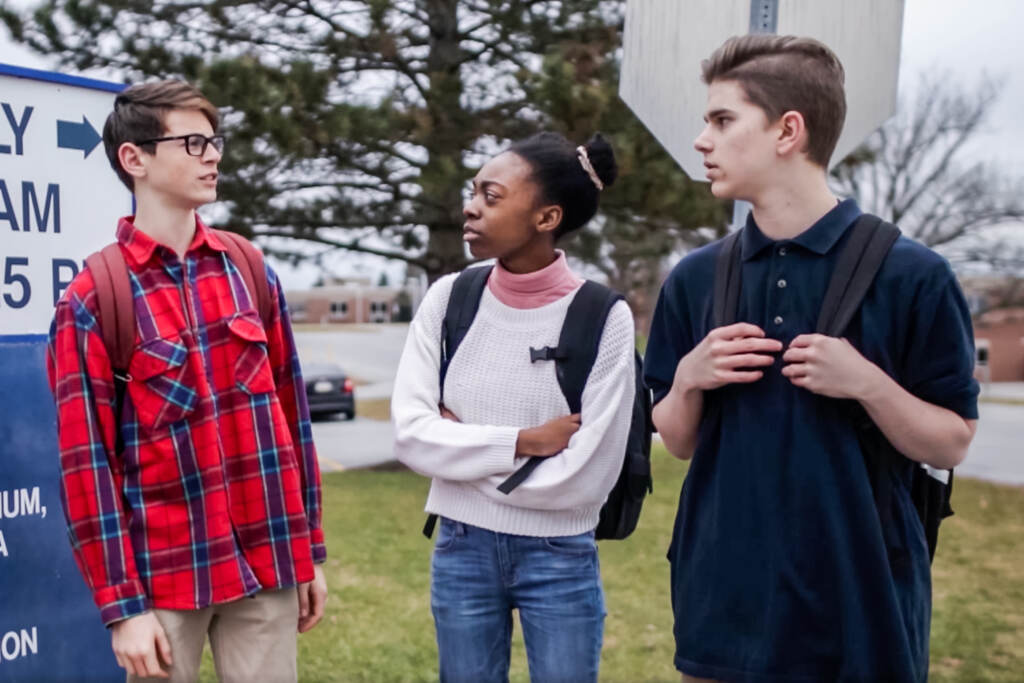YCS-03-WEB-2 Two teenage boys and a teenage girl talking outside of school