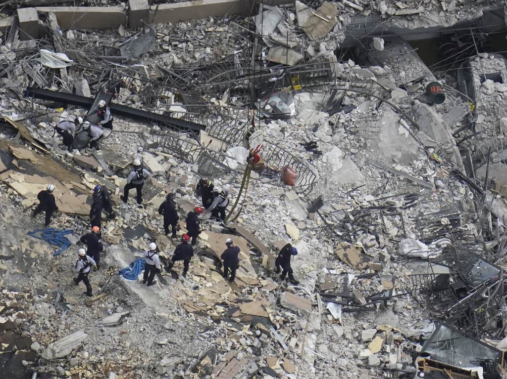 Rescue workers search in the rubble at the Champlain Towers South condo