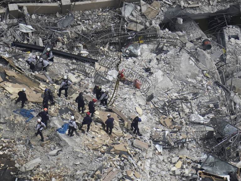 Rescue workers search in the rubble at the Champlain Towers South condo