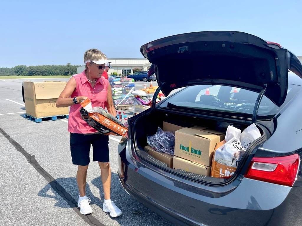 food bank2 Volunteer Judy Stout helps load a trunk with food at the Food Bank of Delaware's monthly drive-thru distribution