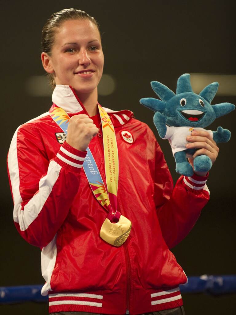 Mandy Bujold holds up a fist and a plush kids toy