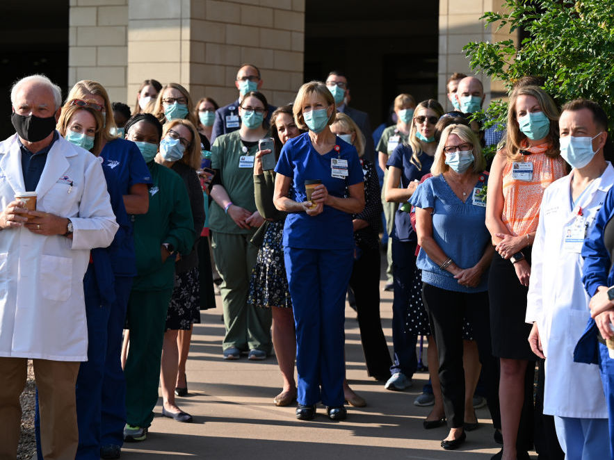 Front-line workers at a medical center in Aurora, Colo., gather for a COVID-19 memorial on July 15 to commemorate the lives lost in the coronavirus pandemic. New estimates say many thousands more will die in the U.S. this summer and fall. Front-line workers at a medical center in Aurora, Colo., gather for a COVID-19 memorial on July 15 to commemorate the lives lost in the coronavirus pandemic. New estimates say many thousands more will die in the U.S. this summer and fall. (Hyoung Chang/MediaNews Group/Denver Post via Getty Images)