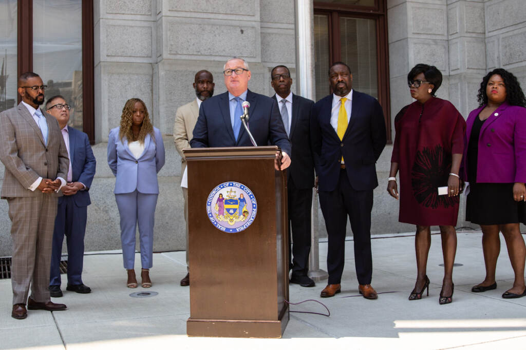 gun_violence_prevention_city_jall_KP_072821_03 Jim Kenney speaks from a podium, with other elected officials behind him