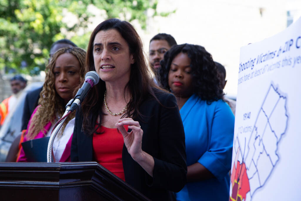 philly_gun_violence_presser_KP_072221_01 Rebecca Rhynhart speaks from a podium at a press conference, with elected officials behind her