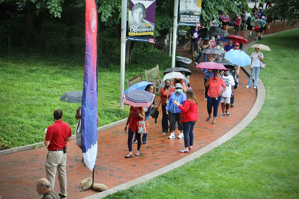 People stand in the rain outside the National Constitution Center