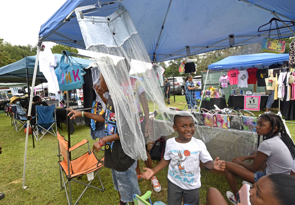 A family is pictured at a booth at the grand opening of the Mask Melanin Market in Glassboro NJ