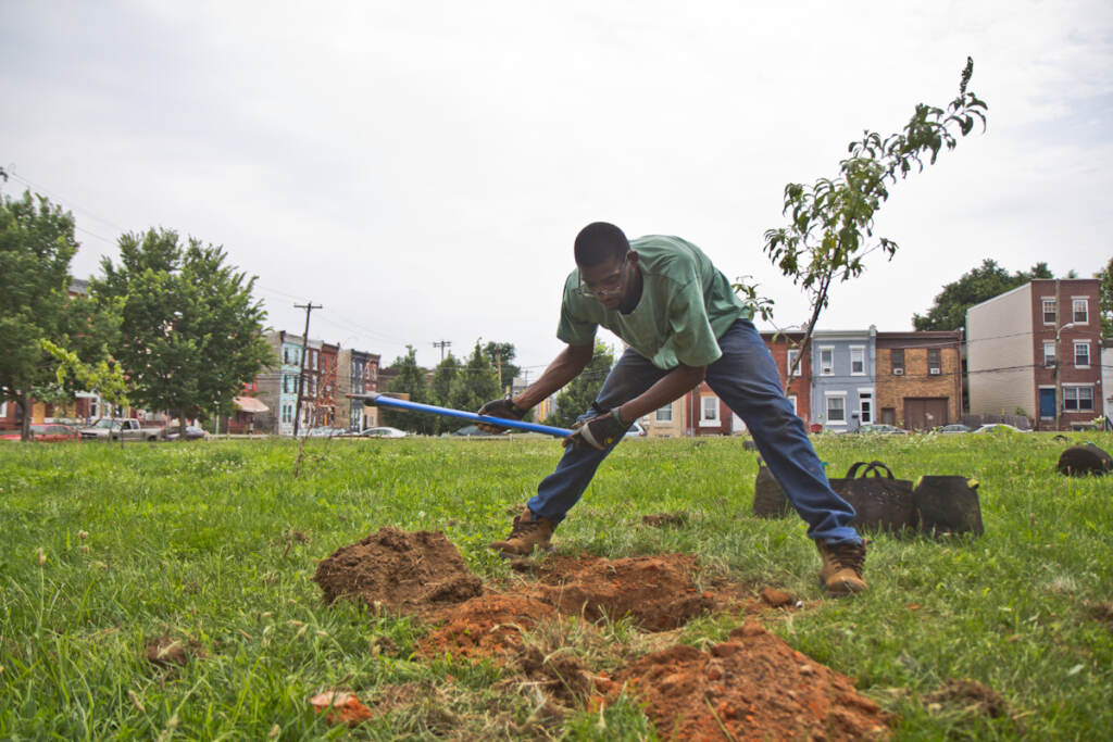 2021 07 11 k paynter tree planting Norris Street-7 Garrison Hines plants fruit trees at a lot on the 1900 block of Norris Street in Philadelphia.