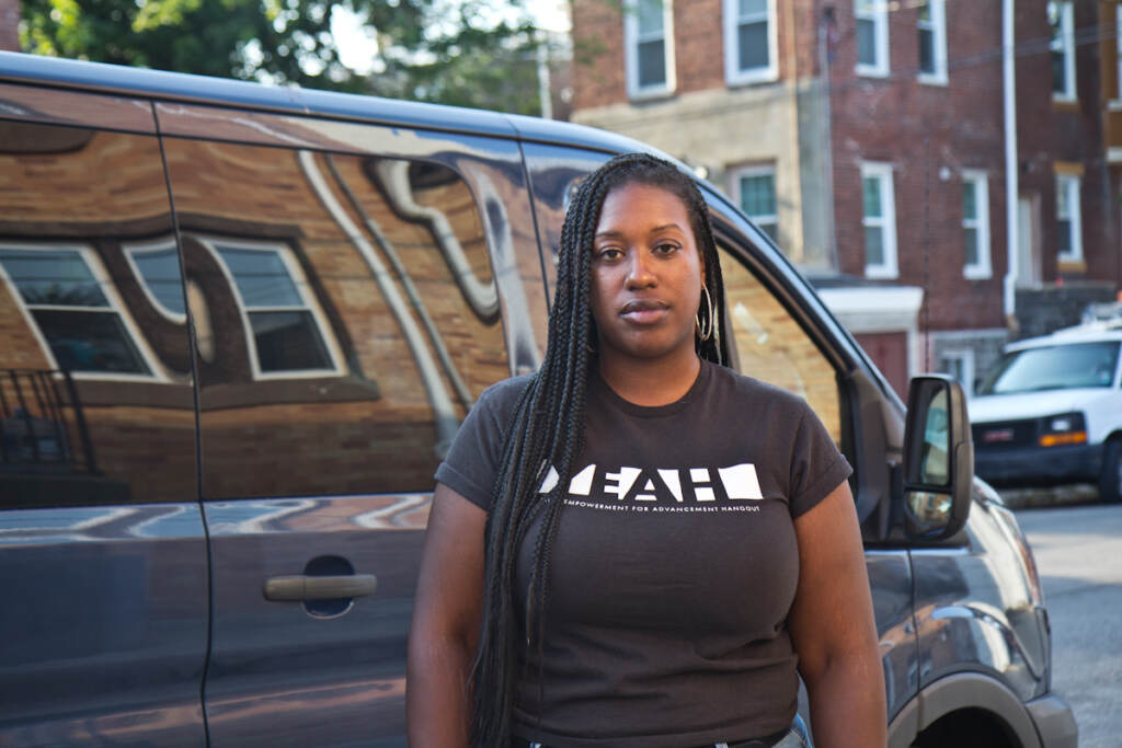 Kendra Van de Water stands in front of a van