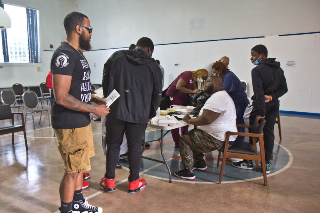 2021 08 11 k paynter carpentry training program-2 Anton Moore (seated), executive director of Unity in the Community, at the orientation for a carpentry training program on August 5, 2021. Moore raised funds for the 20-week program that pays young men a stipend, offers mental health services and provides mentorship opportunities. (Kimberly Paynter/WHYY)