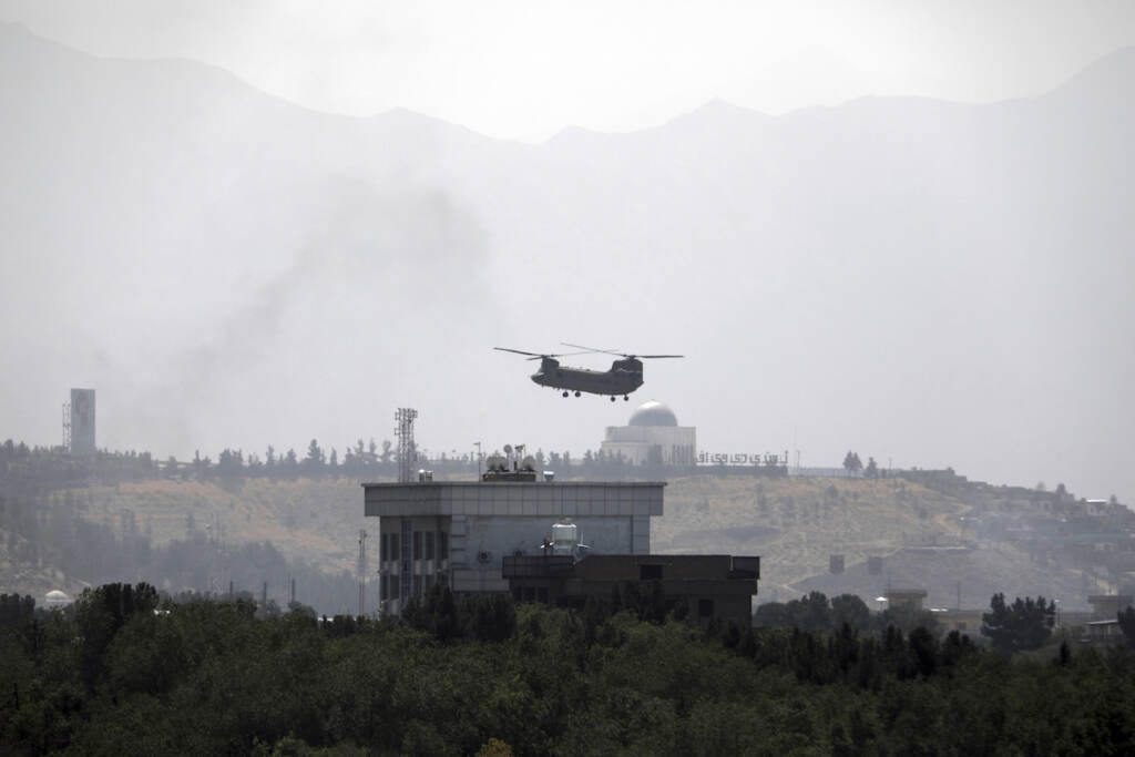 APTOPIX Afghanistan A U.S.Chinook helicopter flies over the U.S. Embassy, in Kabul, Afghanistan, Sunday, Aug. 15, 2021. Helicopters are landing at the U.S. Embassy in Kabul as diplomatic vehicles leave the compound amid the Taliban advanced on the Afghan capital. (AP Photo/Rahmat Gul)
