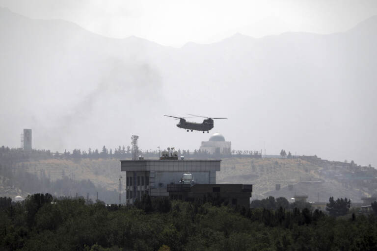 A U.S.Chinook helicopter flies over the U.S. Embassy, in Kabul, Afghanistan, Sunday, Aug. 15, 2021. Helicopters are landing at the U.S. Embassy in Kabul as diplomatic vehicles leave the compound amid the Taliban advanced on the Afghan capital. (AP Photo/Rahmat Gul)